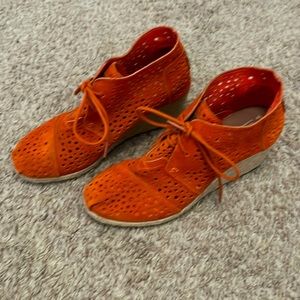 Tom’s orange suede wedge shoe.